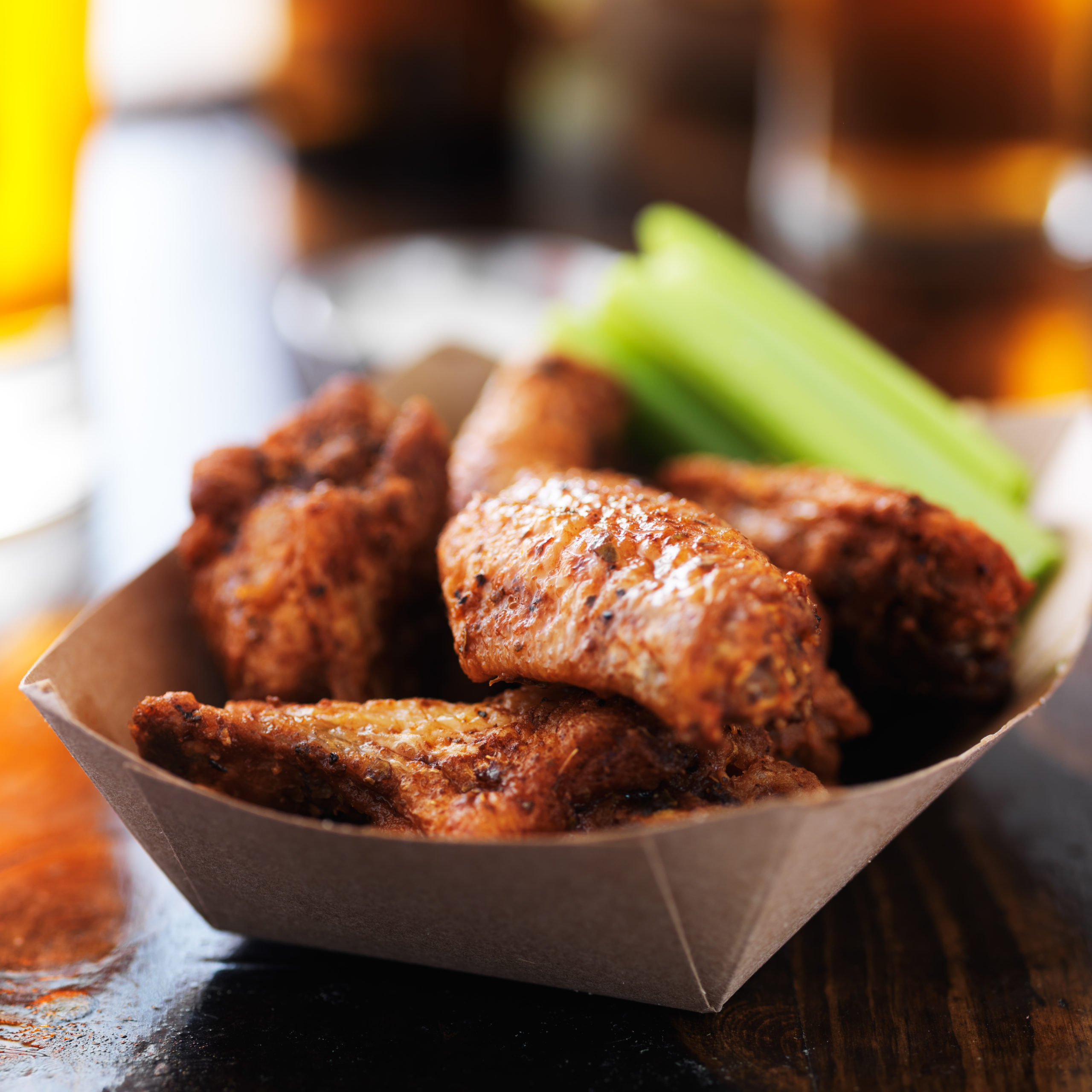 basket of barbcue buffalo chicken wings close up on wooden table