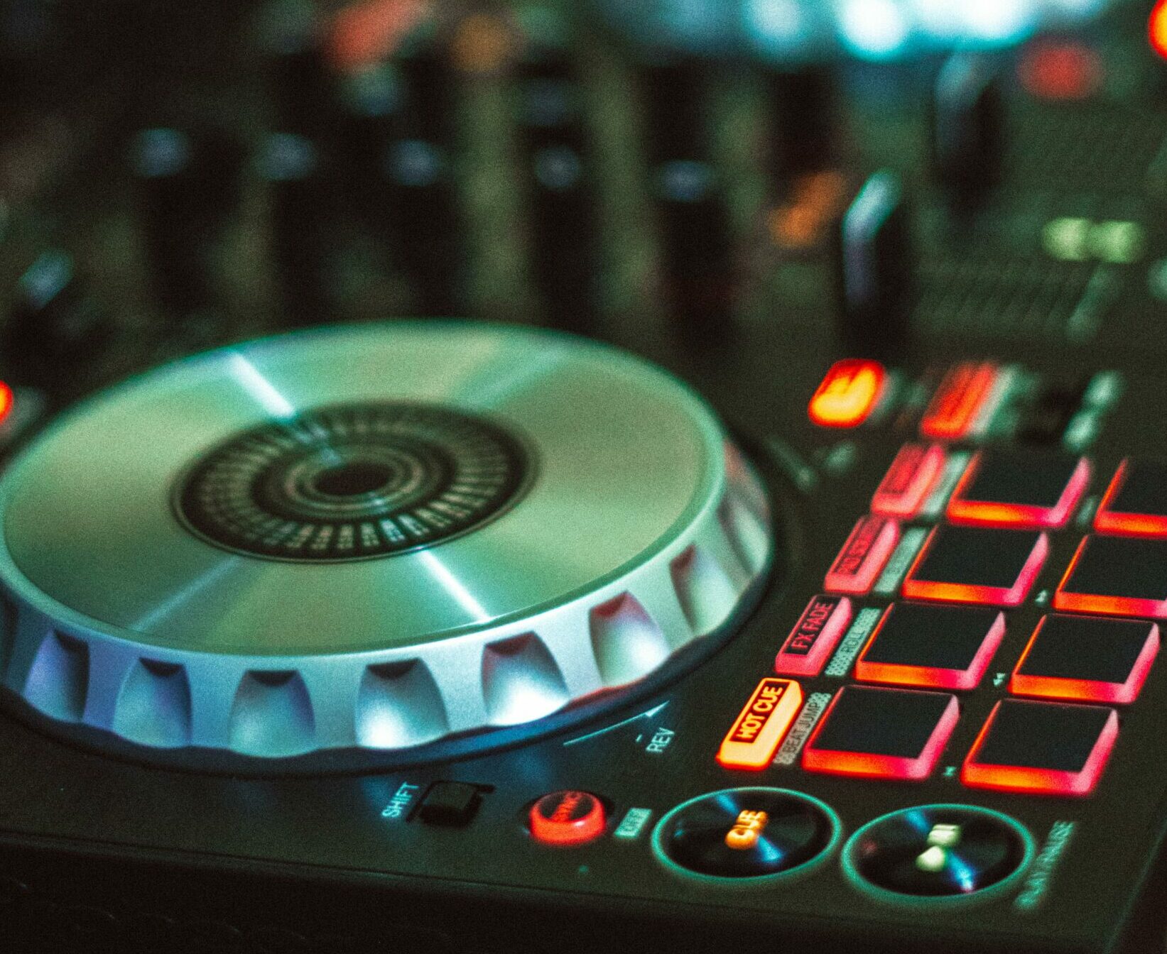 pexels-photo-1481313-1481313 Close-up photo of a DJ controller with illuminated buttons, mixing dials, and controls.